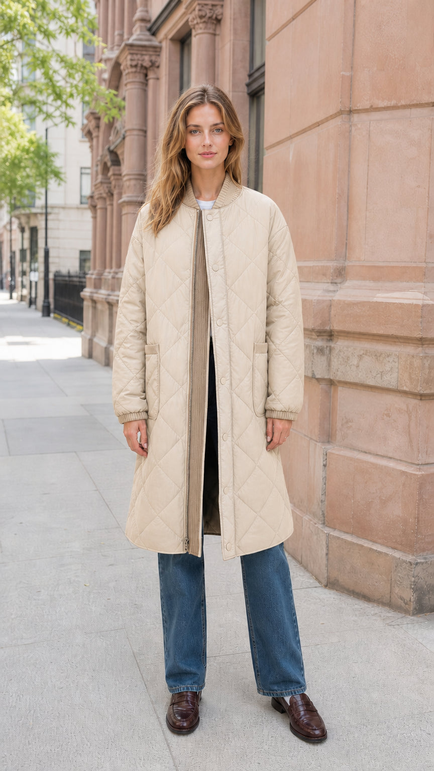 Front view of model wearing beige longline diamond quilted bomber jacket