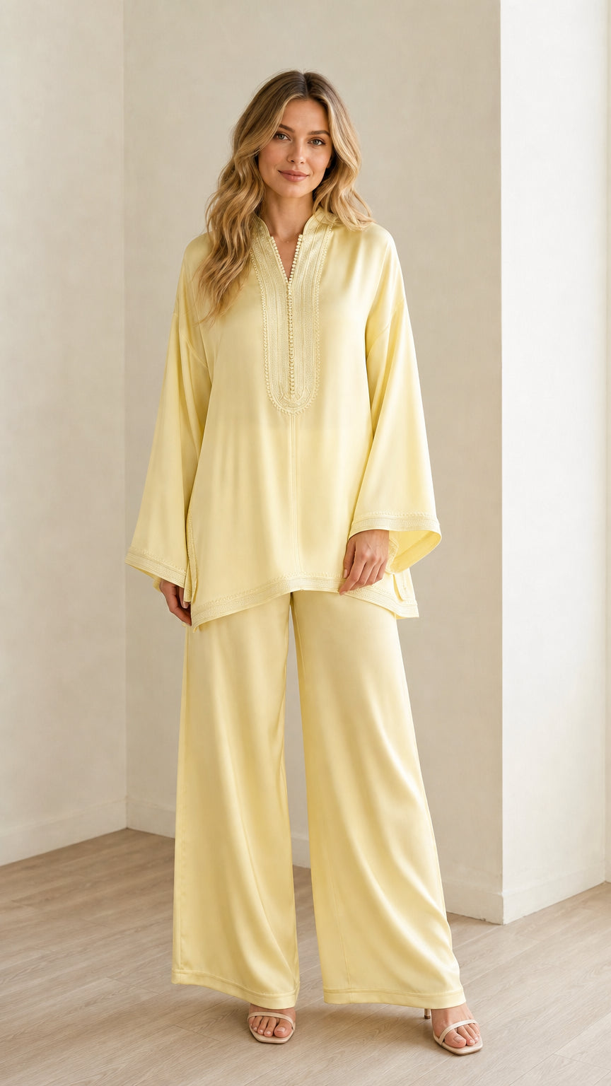 Front full view of woman wearing pastel yellow embroidered tunic and wide-leg trousers set