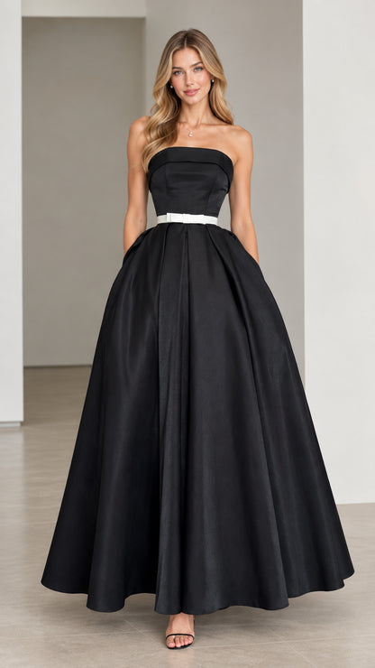 Model wearing black strapless A-line formal evening gown with white waist ribbon