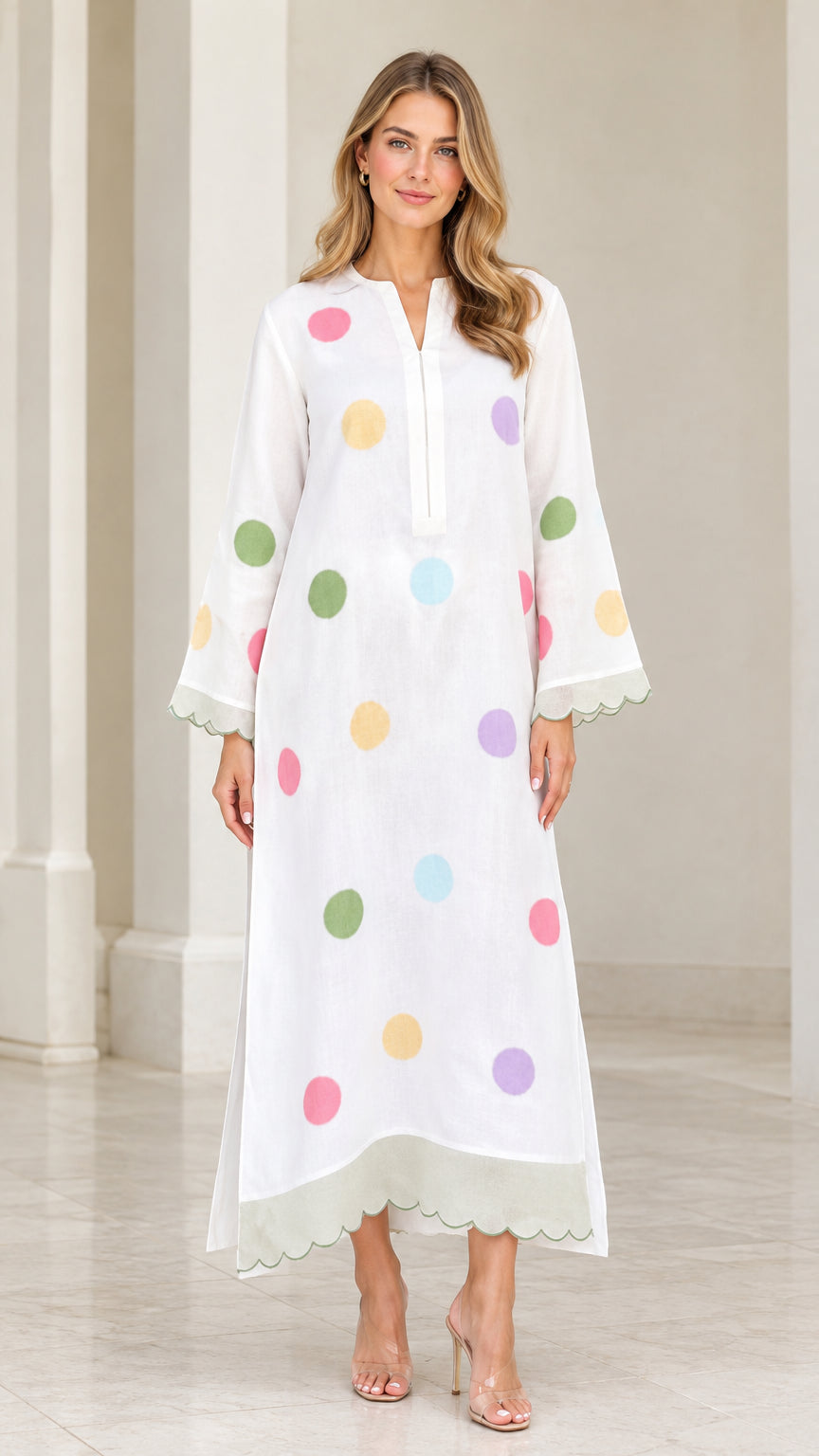 Front view of woman wearing white polka dot long sleeve maxi kaftan dress