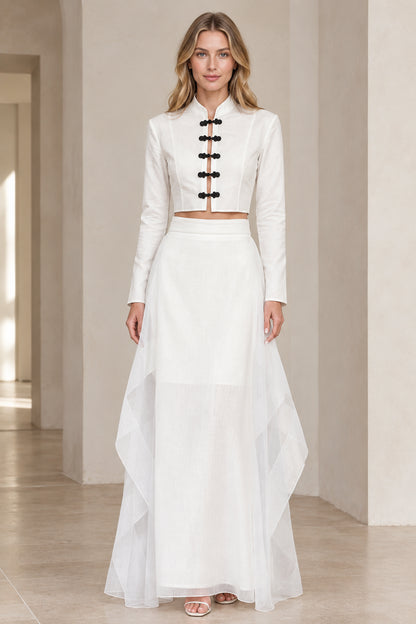 Front view of model wearing white mandarin collar frog button crop top and tiered maxi skirt set
