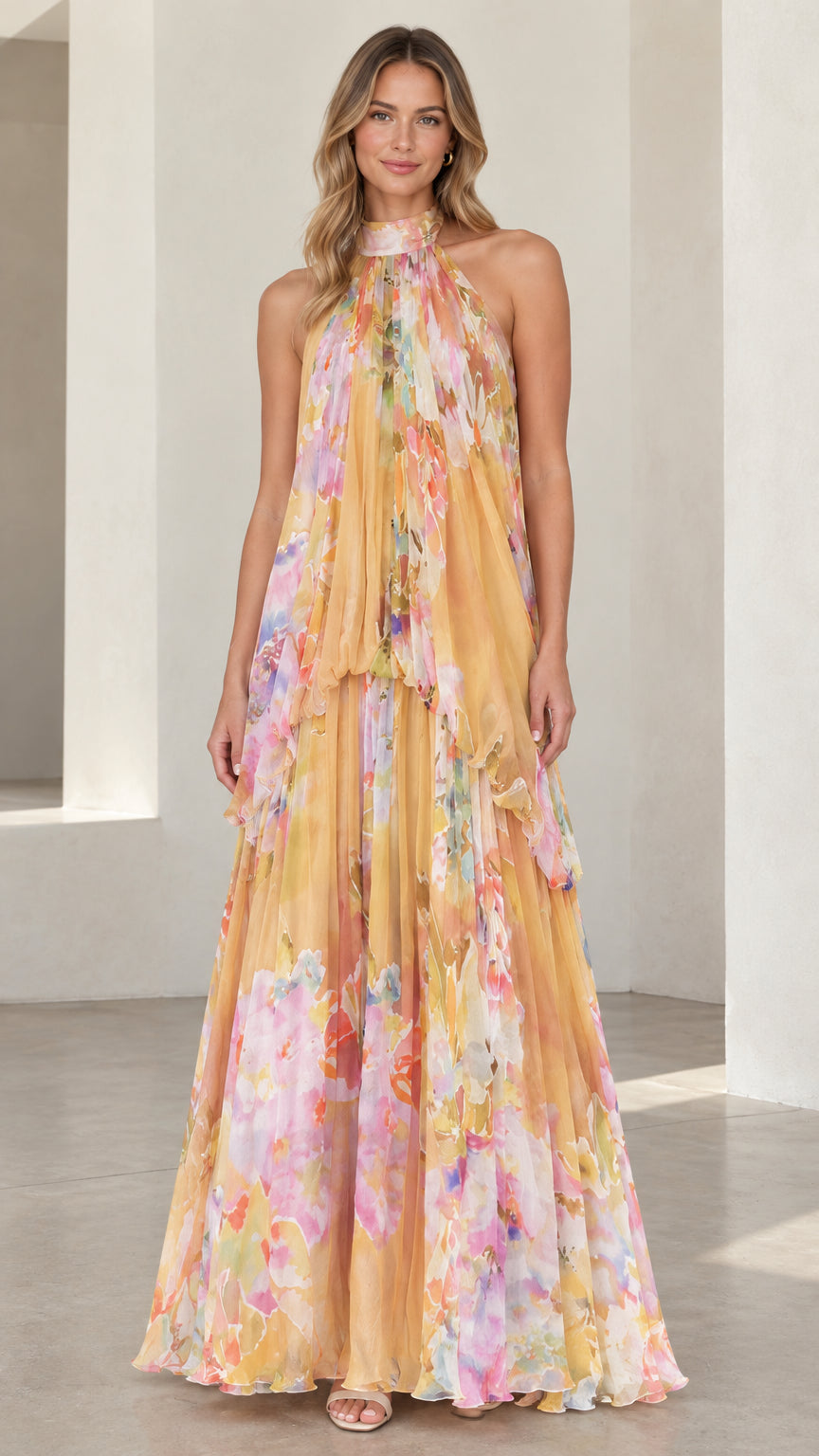 Front view of model wearing a yellow floral halter neck tiered maxi dress