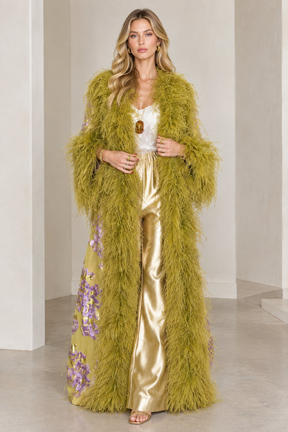 Front full-length view of model wearing olive green floral brocade maxi duster with plush feather trim