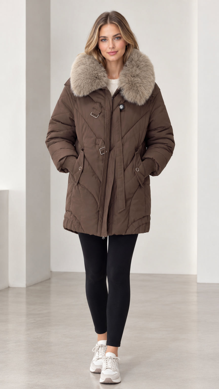 Front view of model wearing brown mid-length quilted puffer parka with plush faux fur collar