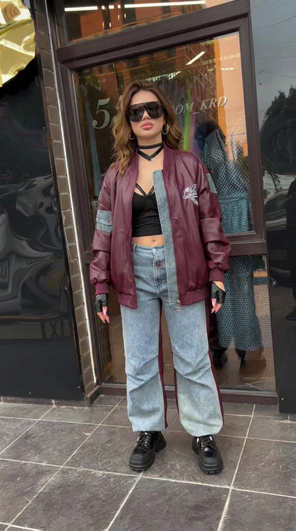 Front full-length view of model wearing burgundy faux leather bomber jacket with denim panels