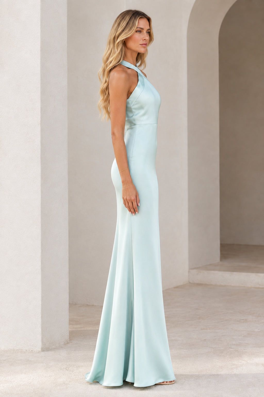 Side profile of woman wearing Ice Blue halter satin formal gown