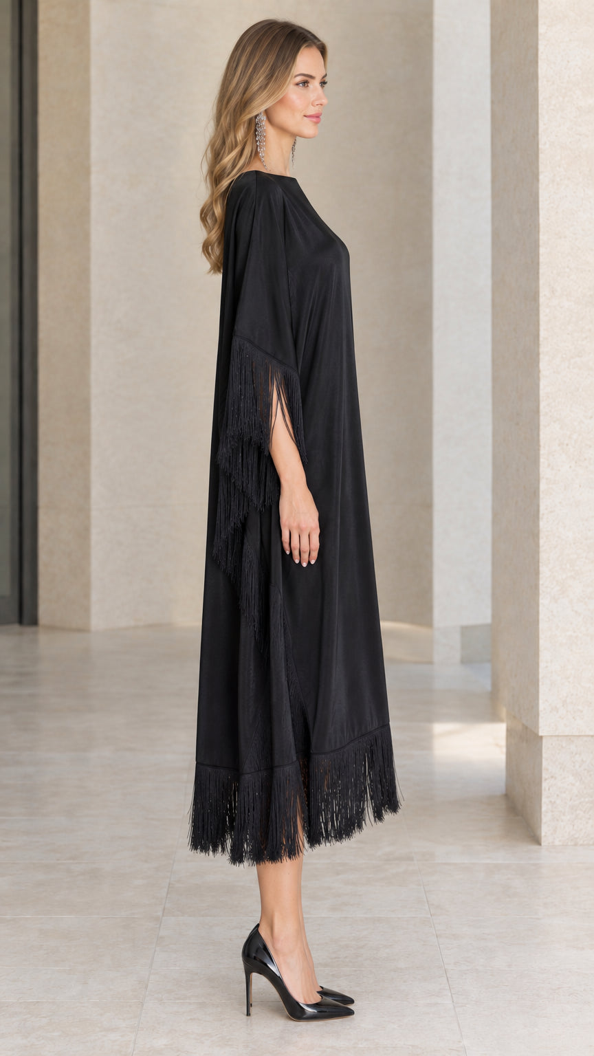 Side profile view of black satin kaftan dress with fringe detailing
