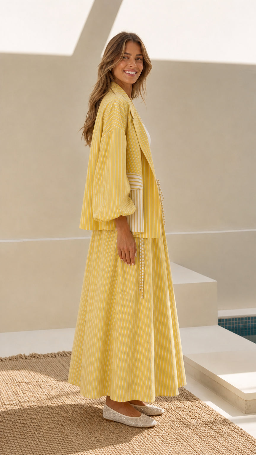 Model wearing yellow striped jacket and maxi skirt set - side profile