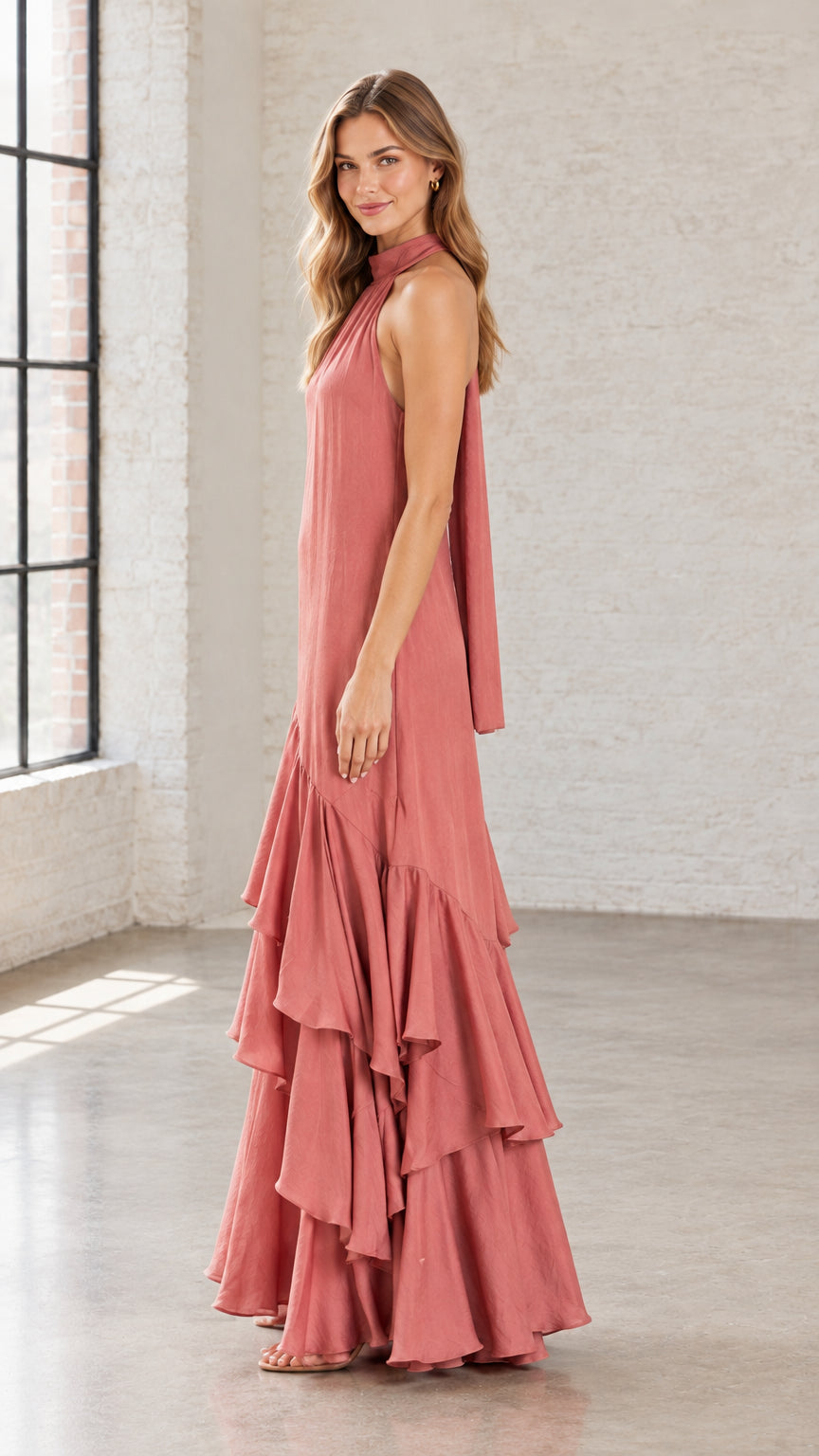 Side angle view of woman in Dusty Rose flowing halter maxi gown