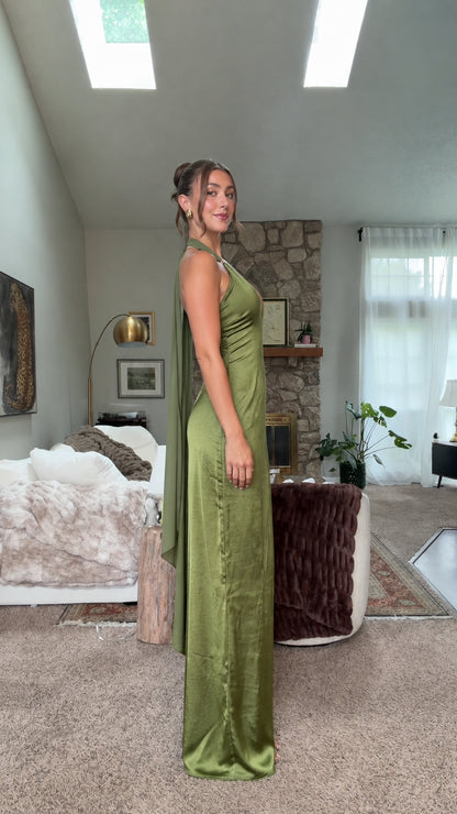 Side profile of olive green satin halter maxi gown with draped detail