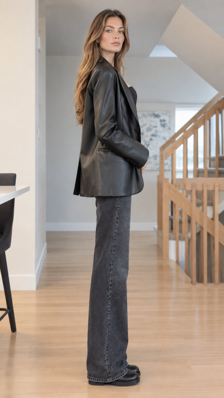 Side full-length view of woman modeling Black faux leather single-breasted blazer