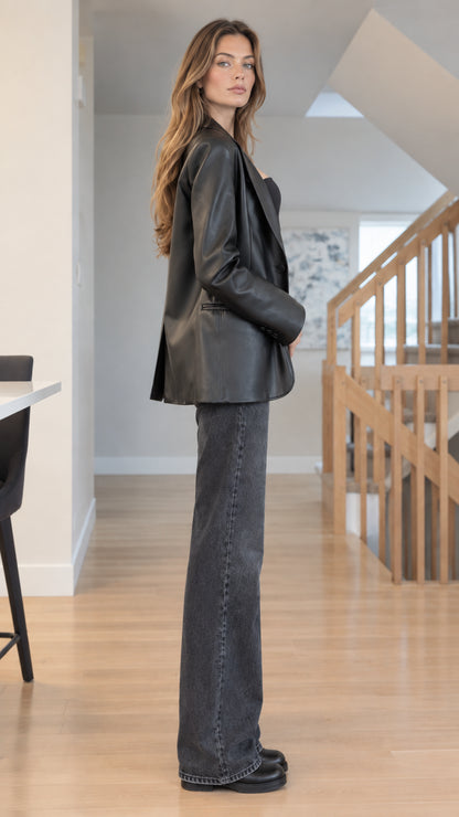 Side full-length view of woman modeling Black faux leather single-breasted blazer