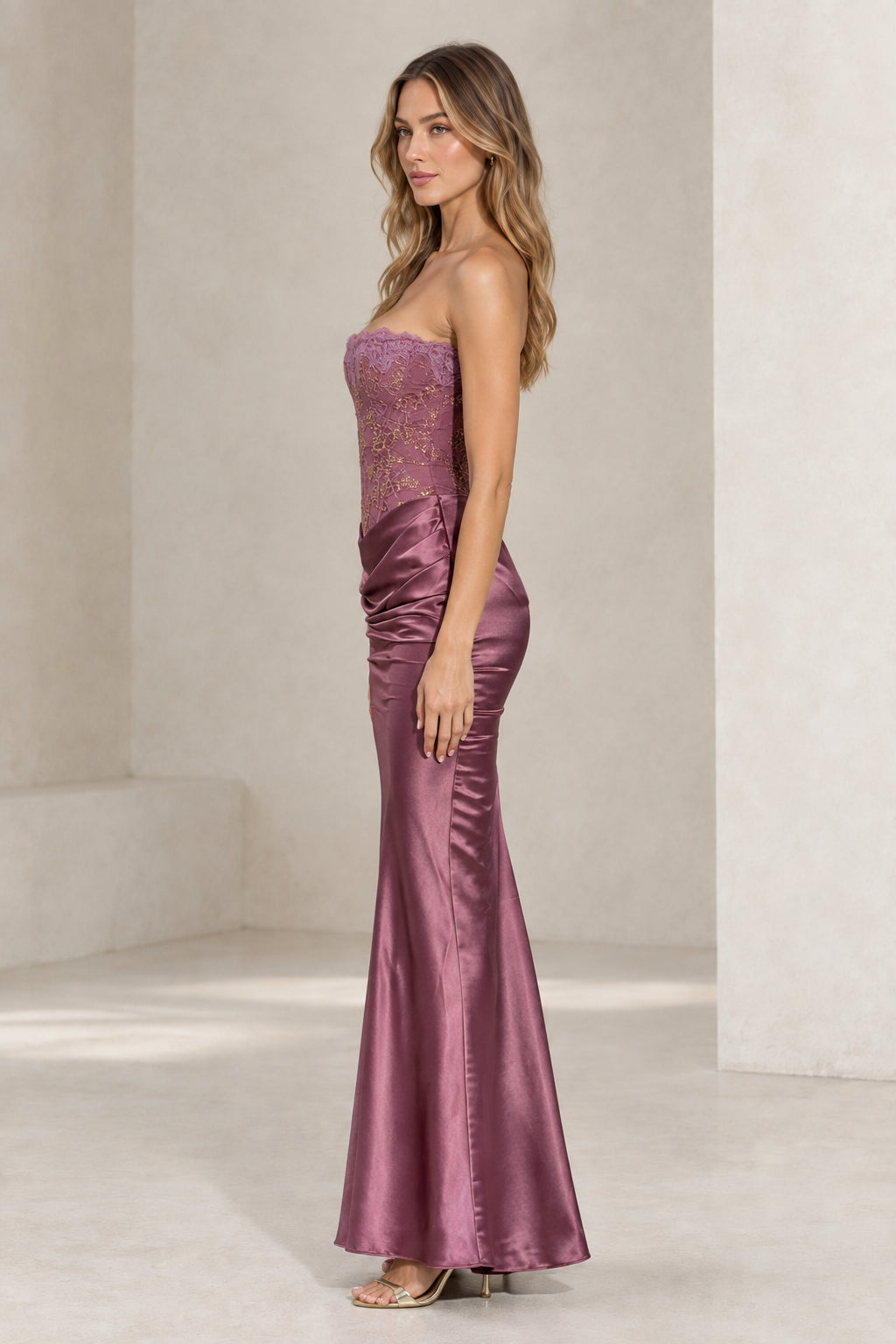 Side profile of woman in mauve lace corset satin mermaid formal gown