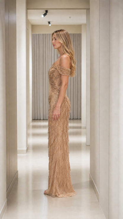Side profile of woman wearing Champagne Gold off-the-shoulder beaded floor-length formal dress