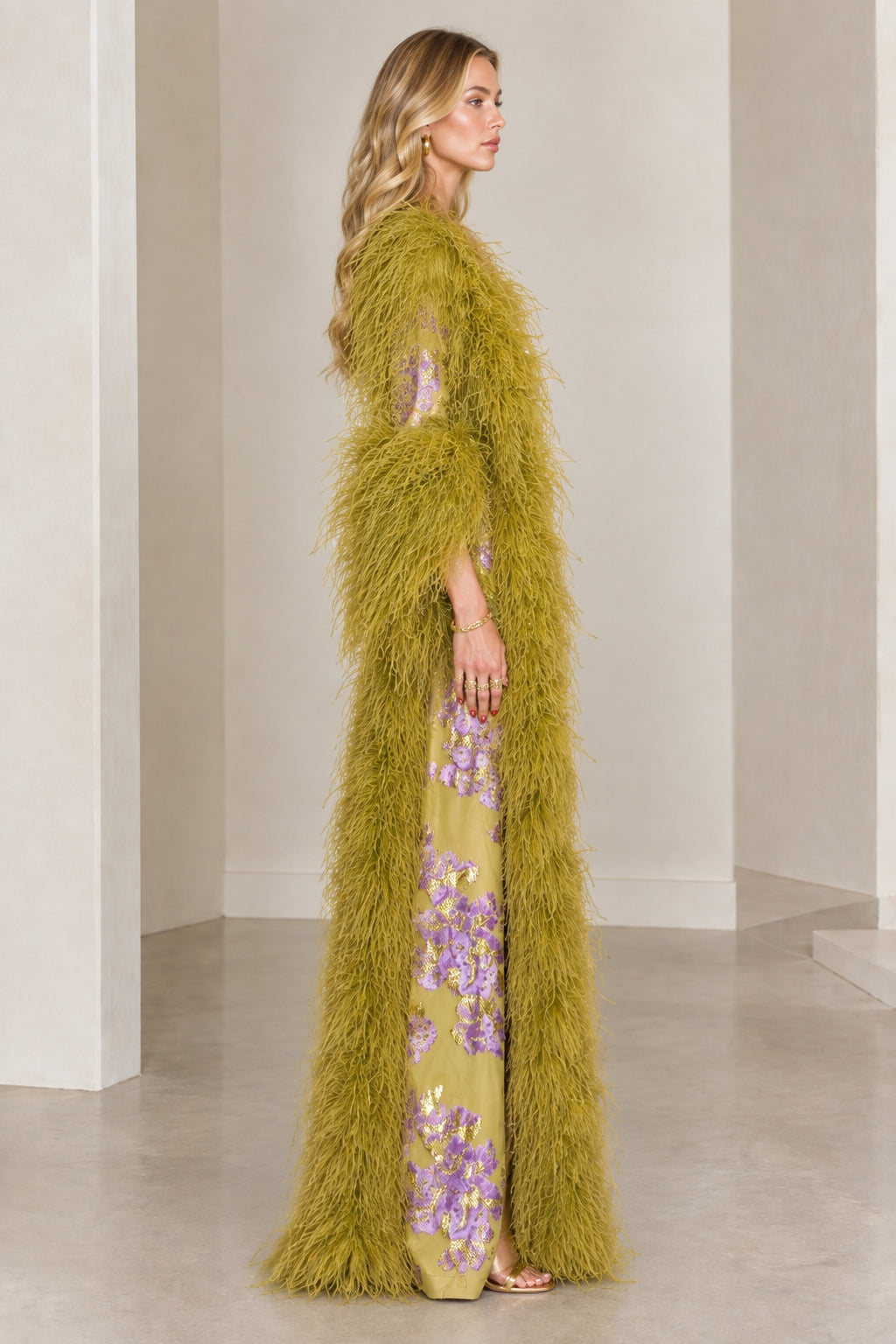 Side profile view of olive green feather-trimmed jacquard evening duster coat