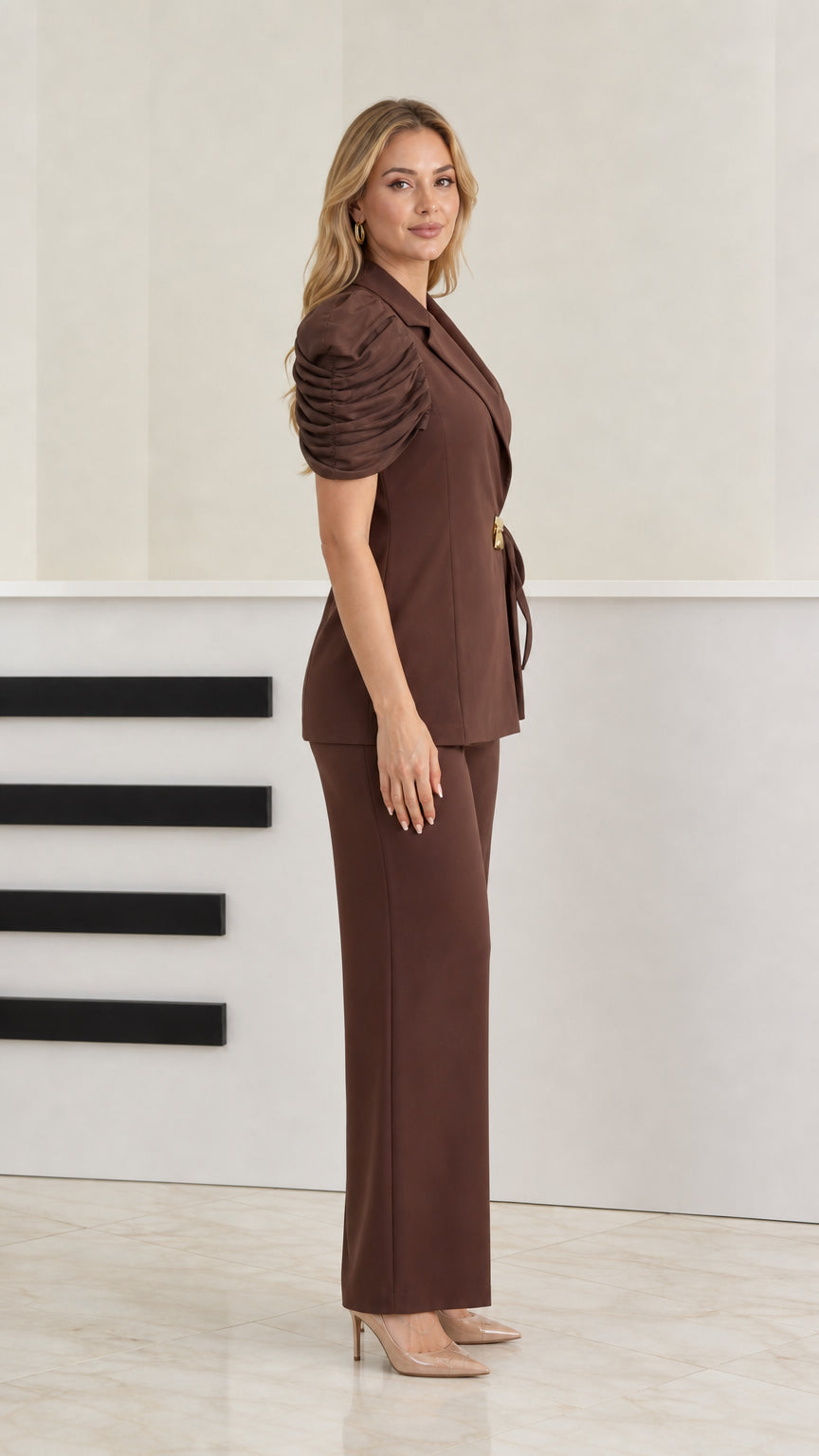 Side profile of model wearing brown 2-piece tailored pant suit set