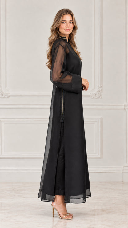 Side profile view of black sheer overlay maxi dress showing fluid drape