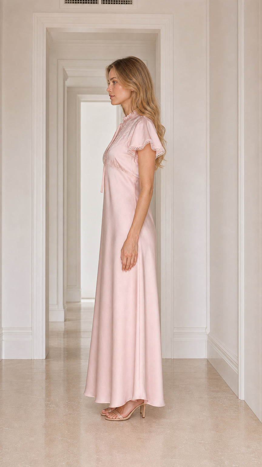 Model wearing pink satin lace-trim maxi dress, side view