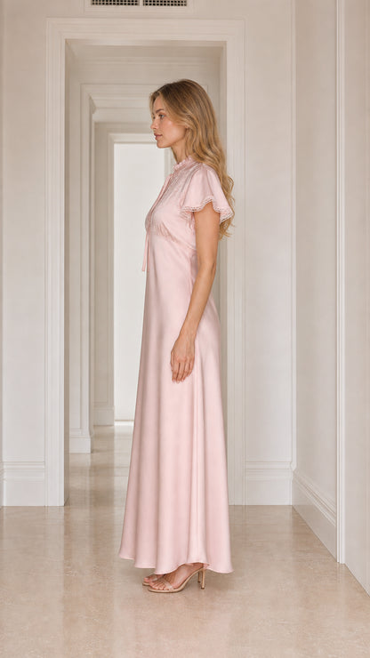 Model wearing pink satin lace-trim maxi dress, side view