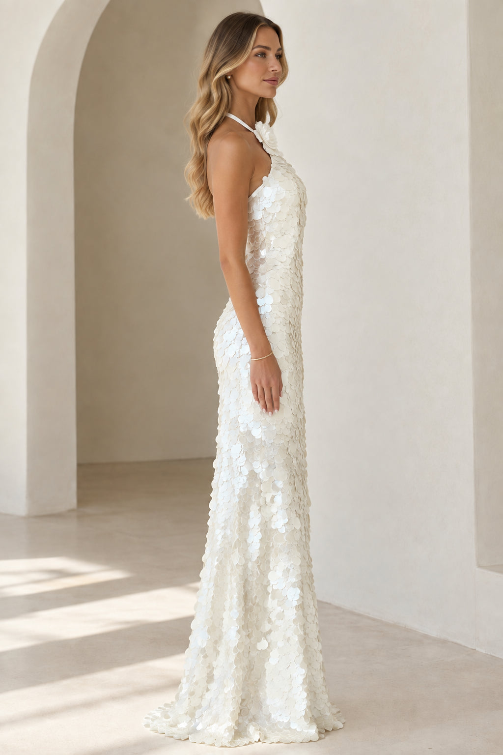 Side profile of white halter sequin evening gown