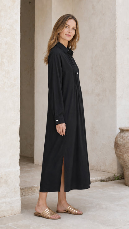 Side angle view of black long sleeve button-down midi dress showing side slit