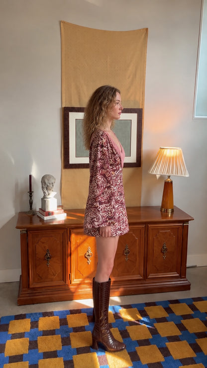 Side profile view of model showcasing bell sleeve drape and mini dress length