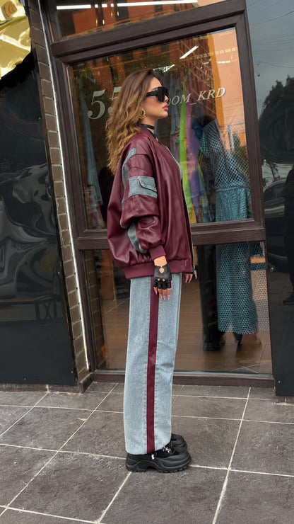 Side profile of model wearing relaxed burgundy faux leather jacket with sleeve pocket