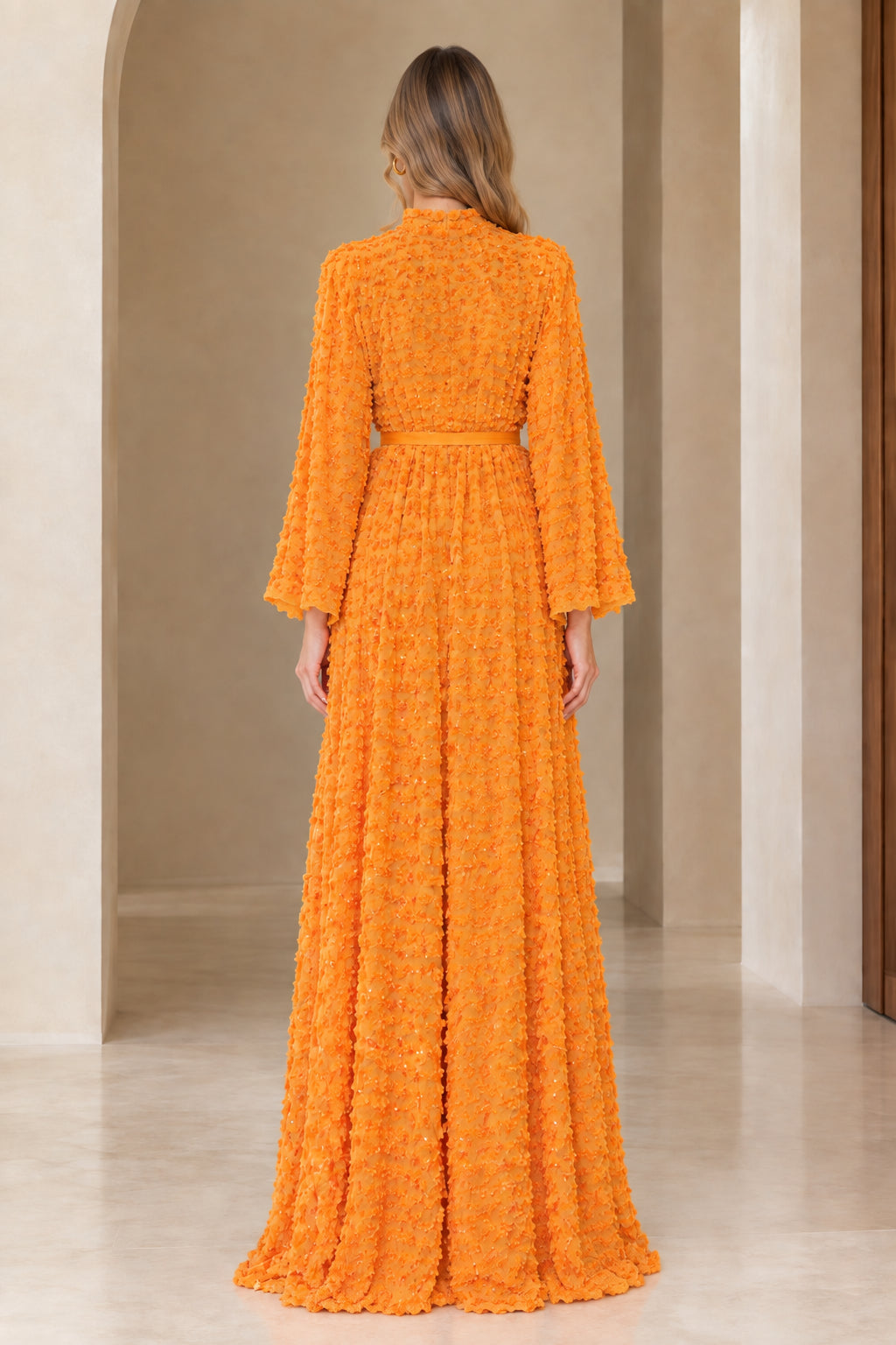 Back full view of long sleeve orange textured sequin maxi dress
