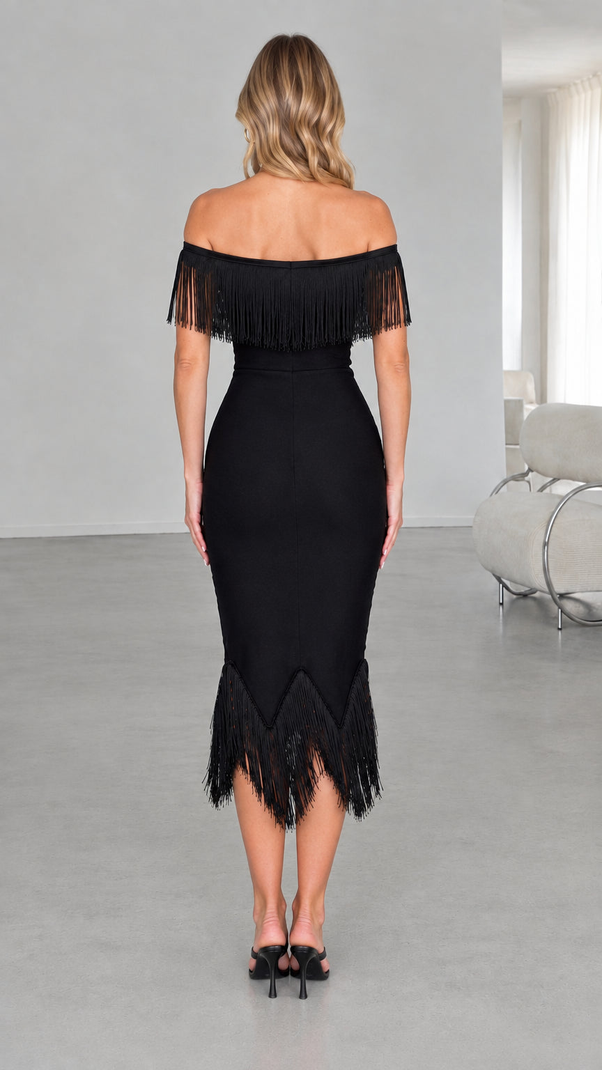 Back view of model in black off-the-shoulder fringe midi dress