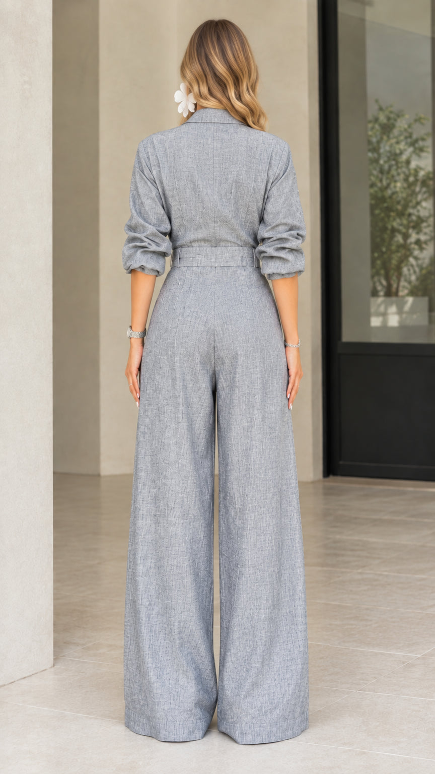 Back view of model wearing grey long sleeve wide leg jumpsuit