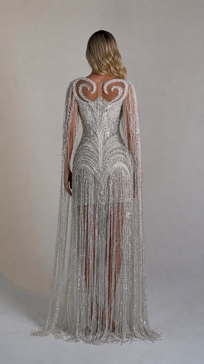 Back view showcasing the flowing cape sleeves and fringe