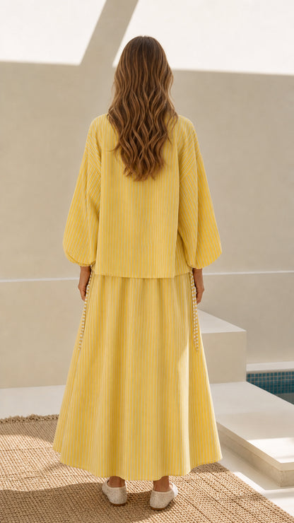 Model wearing yellow striped jacket and maxi skirt set - back view