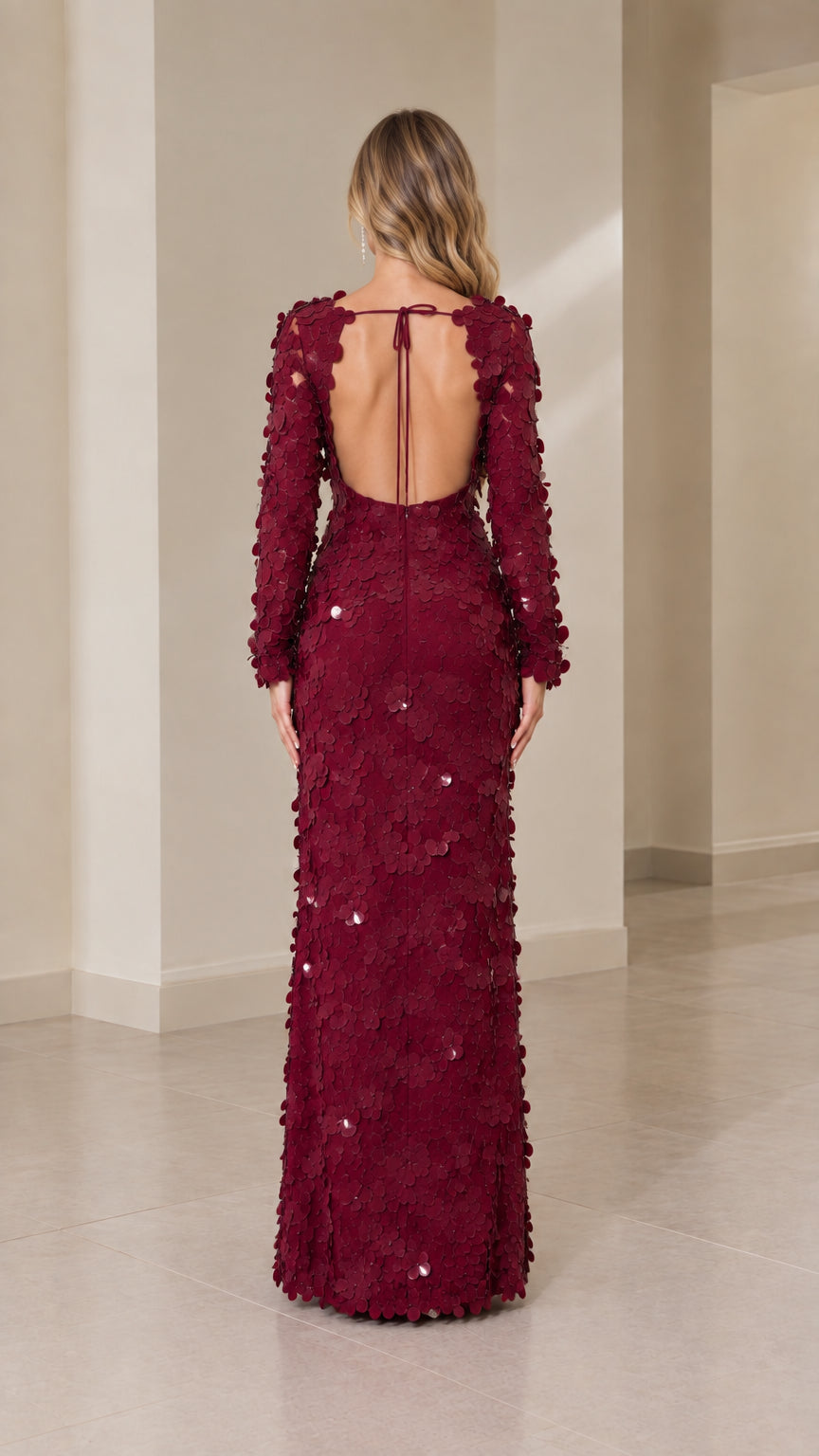Back view of burgundy long sleeve gown showing dramatic open back with tie