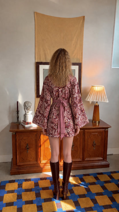Back view of burgundy paisley mini dress highlighting the self-tie waist sash