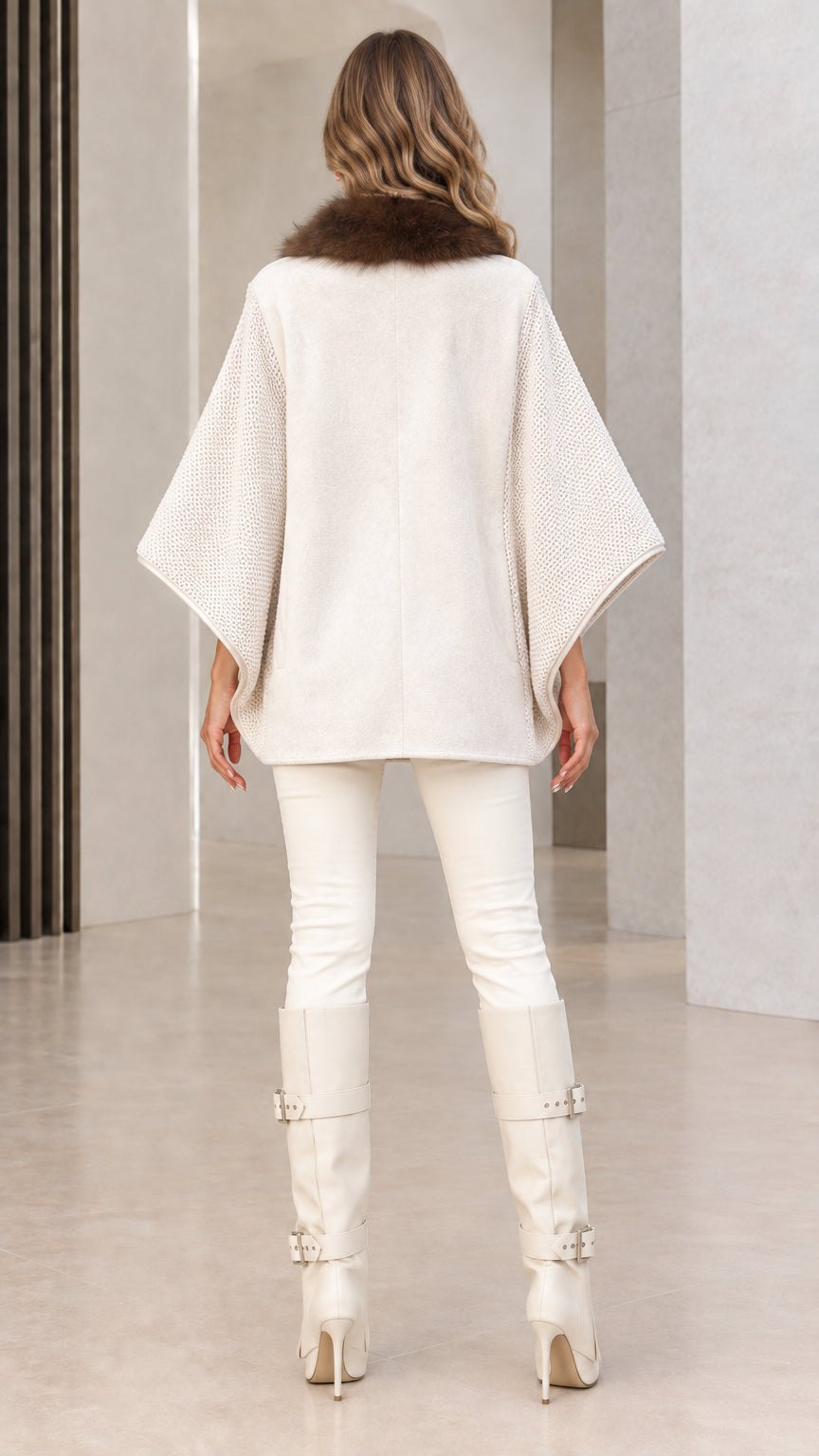 Back view of off-white knit cape cardigan showing drape and sleeve texture