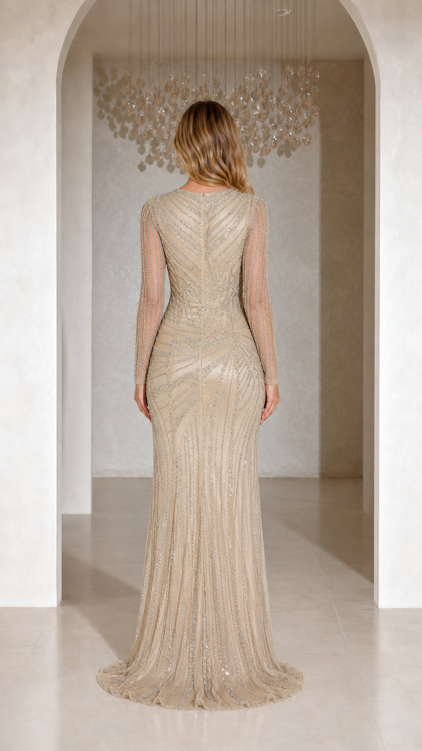 Back view of champagne long sleeve formal dress highlighting tailored fit and subtle train