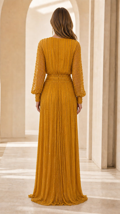 Back view of model showing pleated detailing on mustard yellow gown