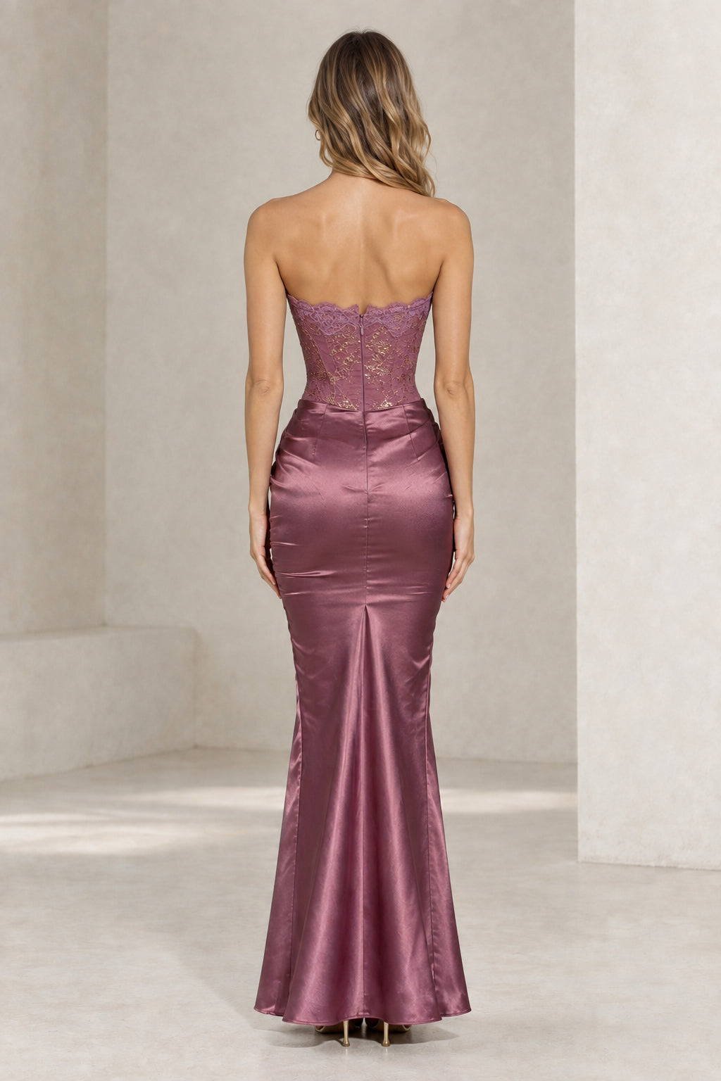 Back view of woman wearing mauve strapless satin maxi dress