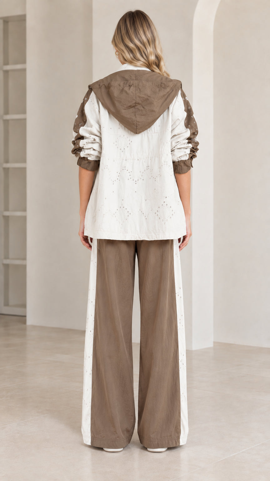 Back view of model wearing hooded jacket and wide-leg track pants in mocha
