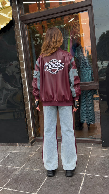 Back view of model showcasing large vintage varsity embroidery on burgundy bomber jacket