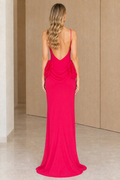 Back view of fuchsia maxi dress highlighting the low open back and rosette waist accent
