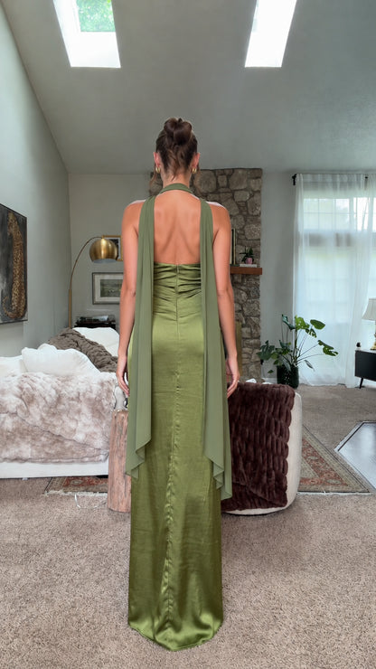 Back view of olive green satin halter dress showing open back and draping