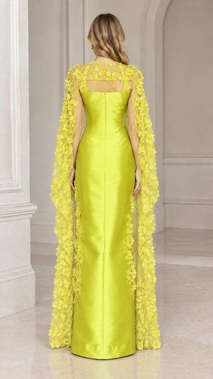 Back view of lime green evening gown showing long sheer floral cape draping