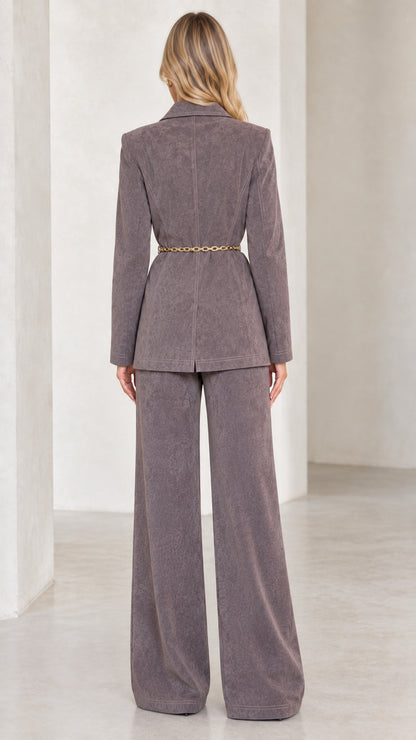 Back view of charcoal grey two-piece suit showing belted waist and clean trouser drape