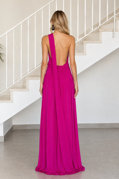 Back view of model wearing magenta maxi dress with open back and draped shoulder strap