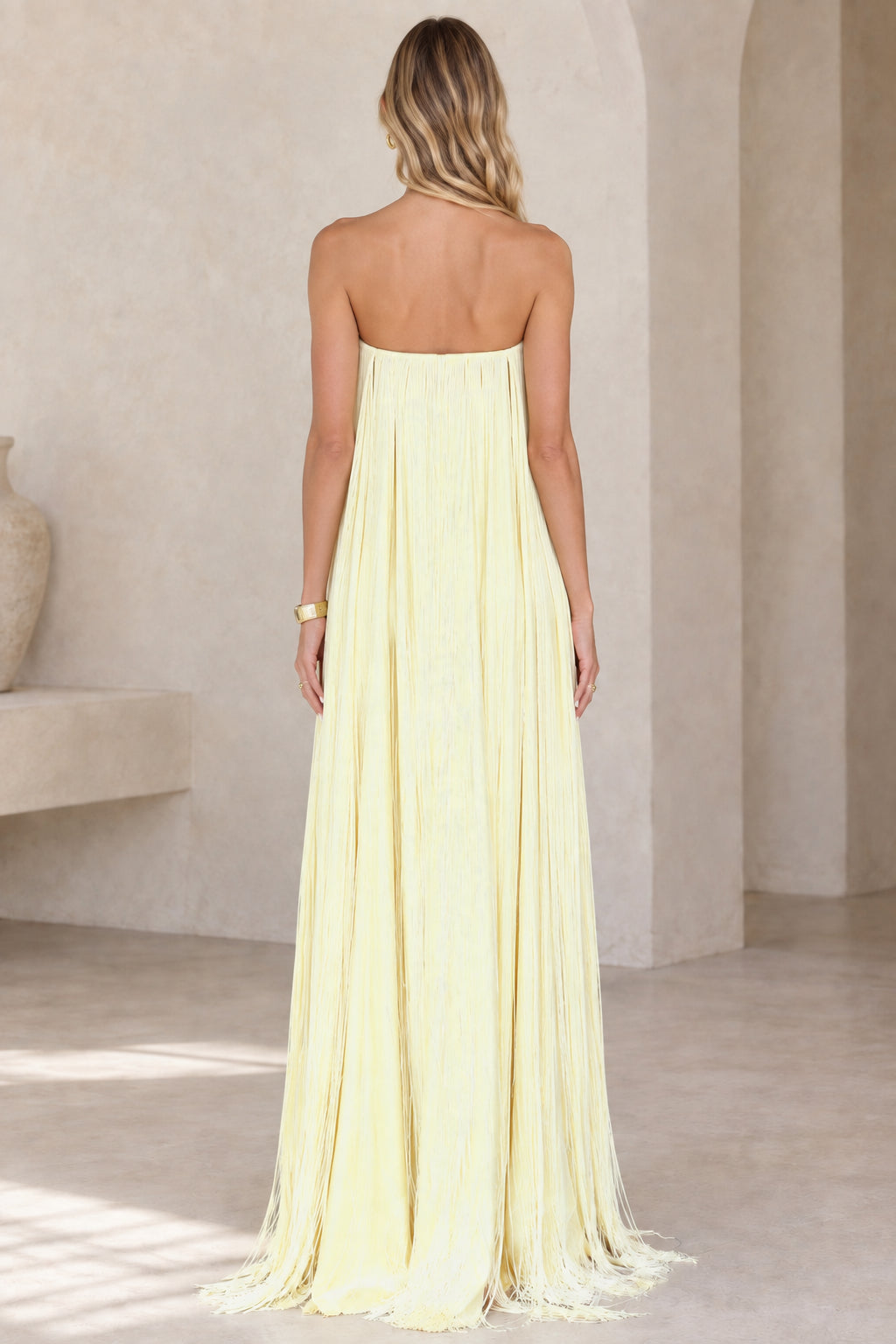 Back view of strapless butter yellow maxi dress with back zipper detail