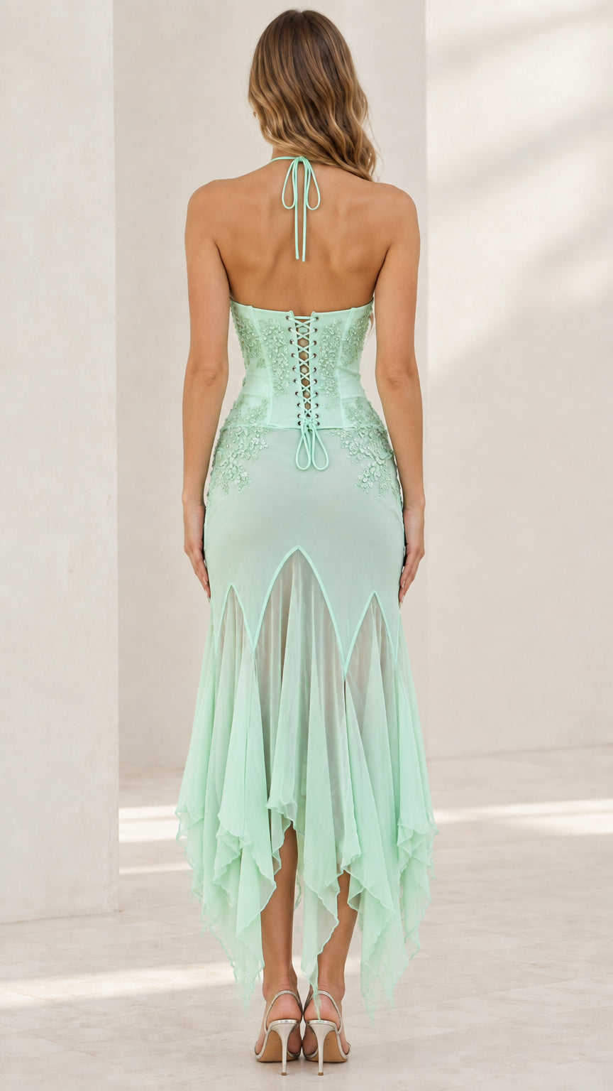 Back view of mint green dress highlighting halter tie and lace-up corset back
