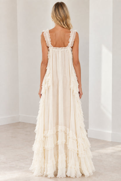 Back view of model wearing cream flowy tiered ruffle maxi dress