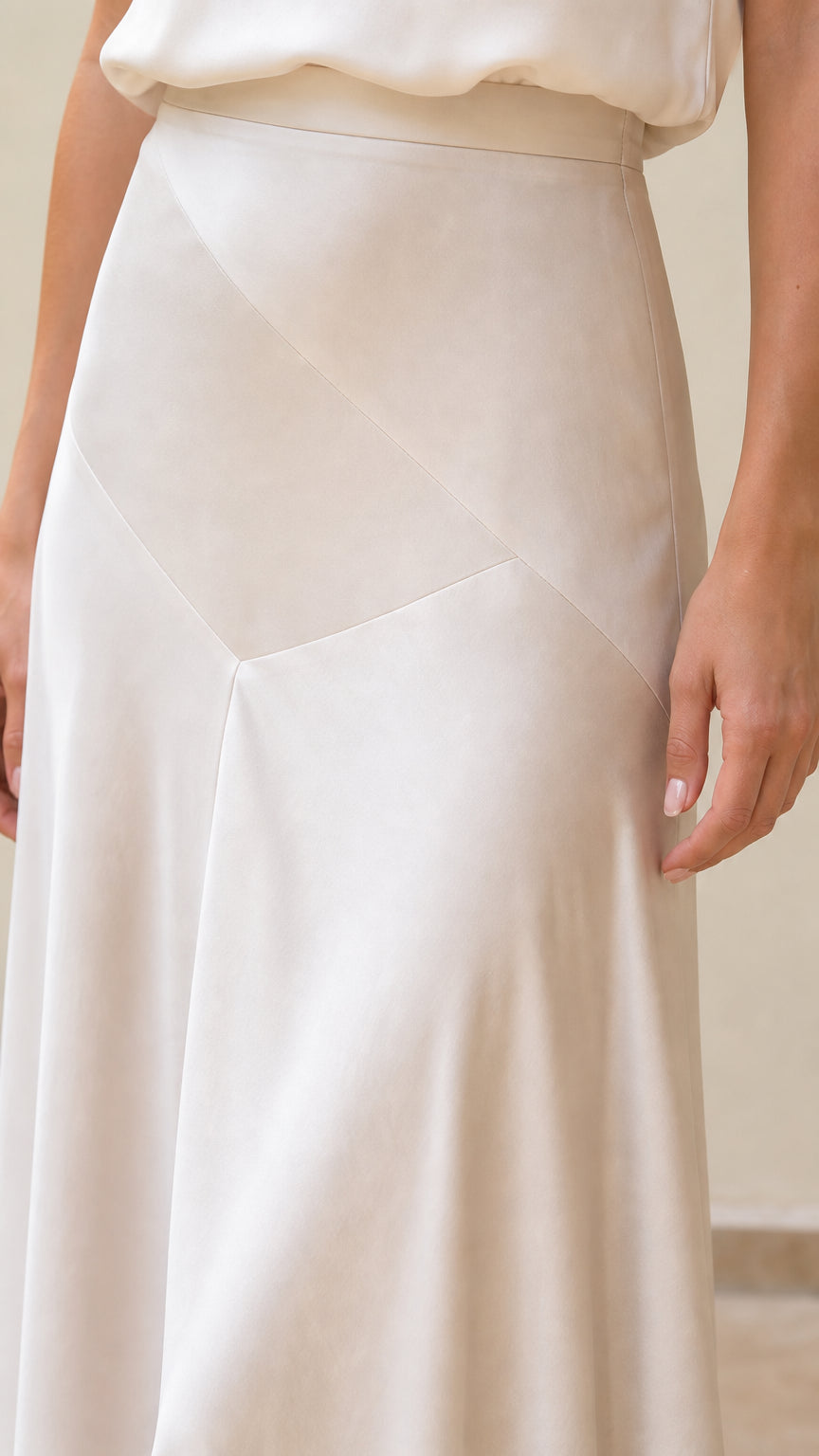 Close-up detail of geometric panel seam on ivory maxi skirt