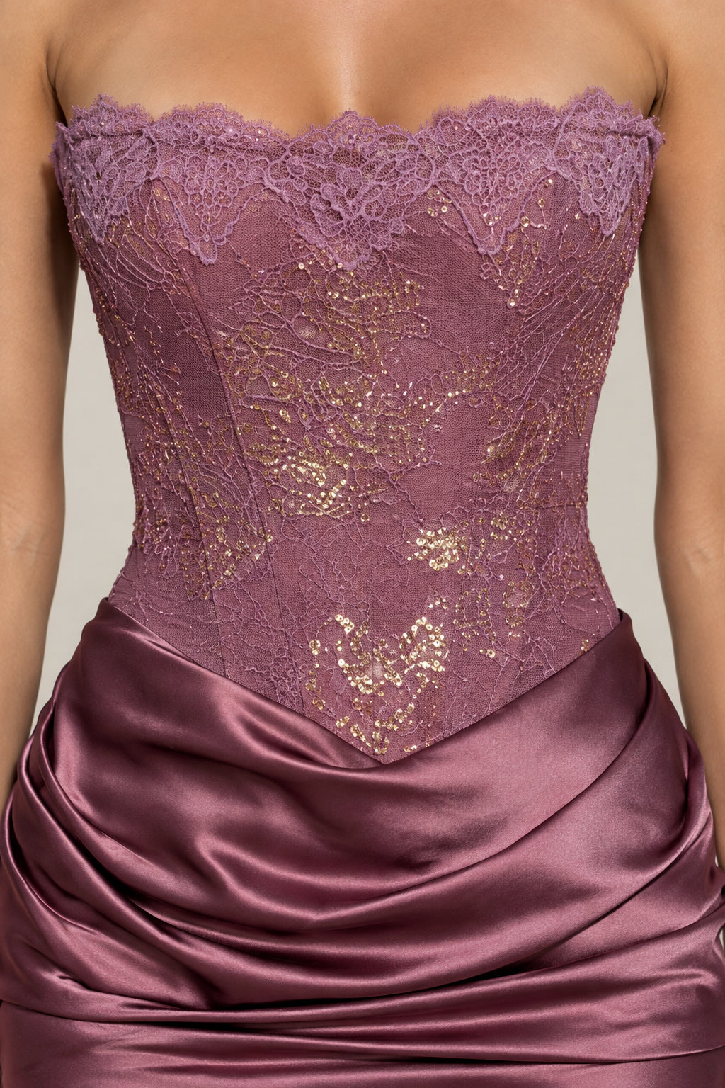 Close-up detail of mauve lace bodice with boning and ruched satin waist